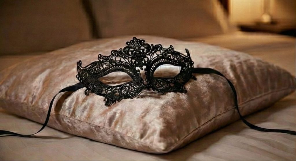 Roleplay. Un antifaz de una fiesta elegante de estilo victoriano, colocado sobre un almohadón de satín.