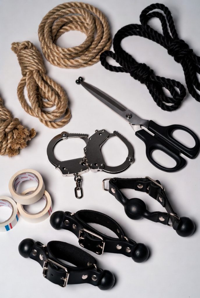 Elementos esenciales para bondage: cuerdas, tijeras de seguridad, cintas, esposas y mordazas.