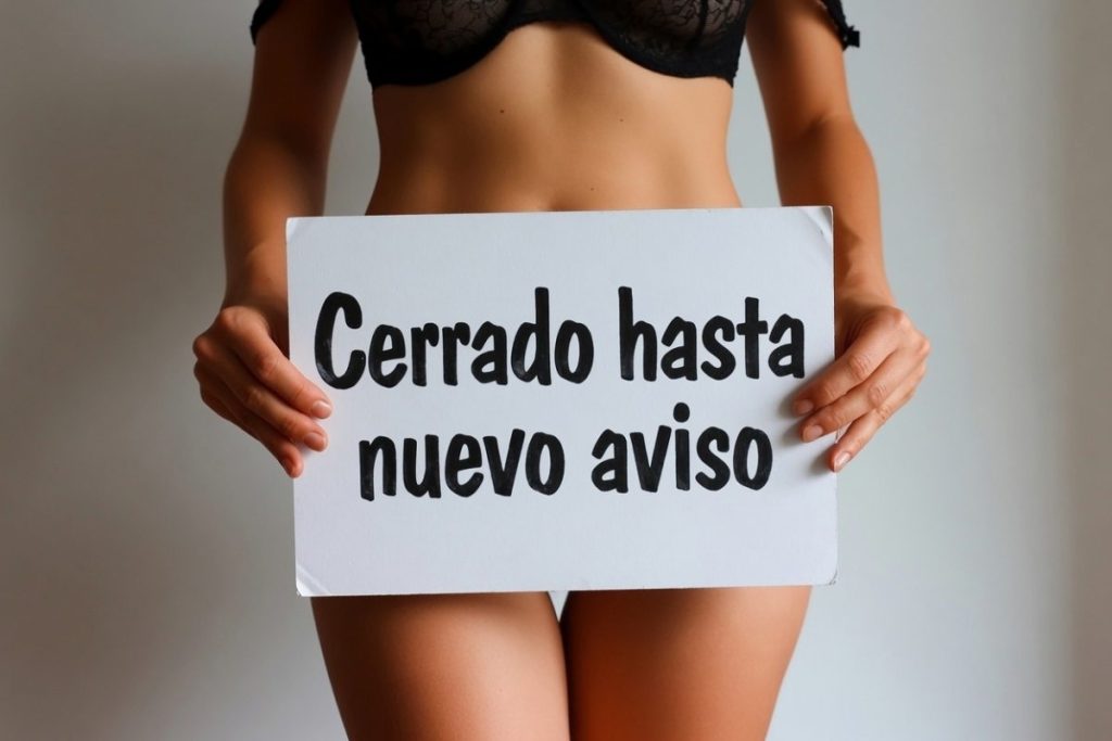 Mujer en ropa interior sosteniendo un cartel que oculta su entrepierna y dice: "Cerrado hasta nuevo aviso"